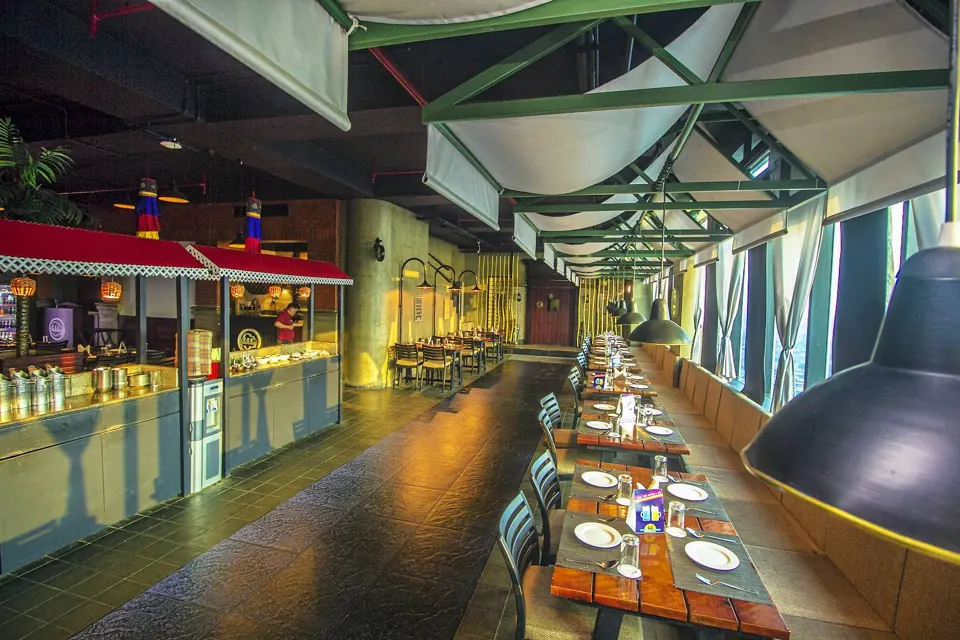 The covered dining hall at Skkky, Siliguri, with long tables under the canopies