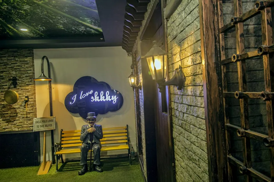 The &lsquo;I love Skkky&rsquo; neon sign above the yellow bench at Skkky, Siliguri