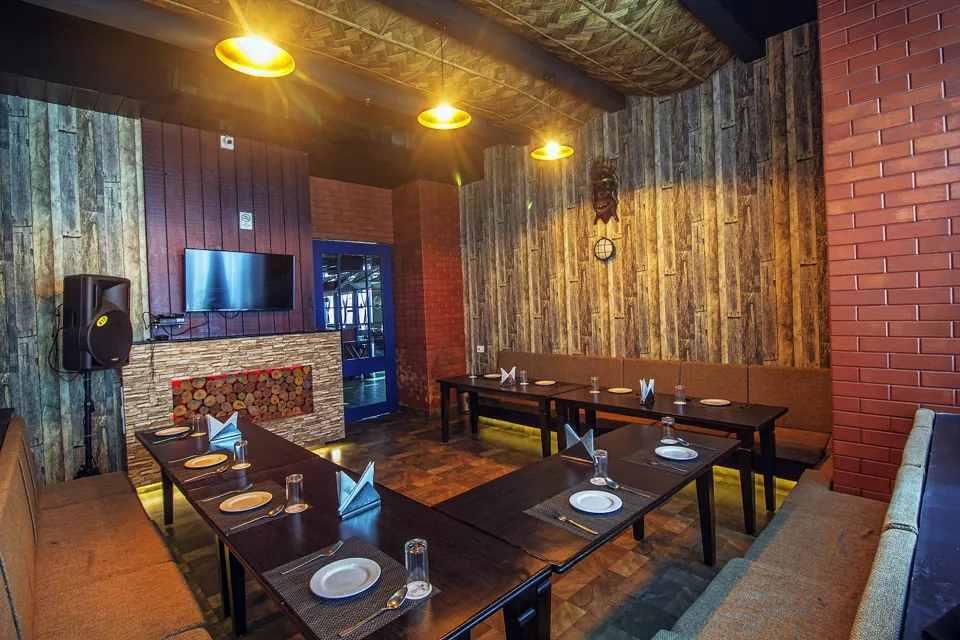 Private room with a wall-mounted screen and sofa seating at Skkky, Siliguri